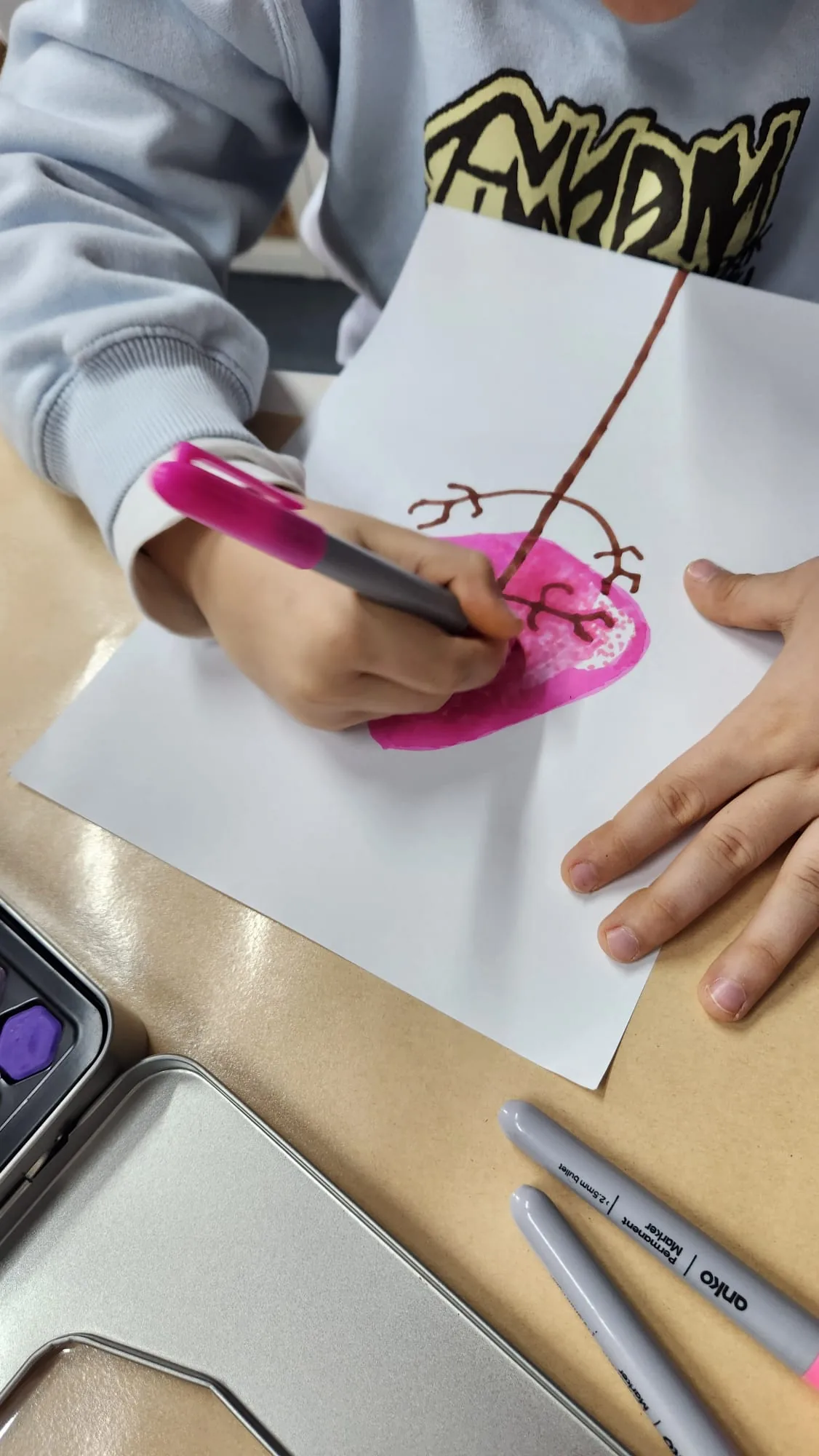 A child drawing with coloured pencils at the Enso Art Therapy studio table